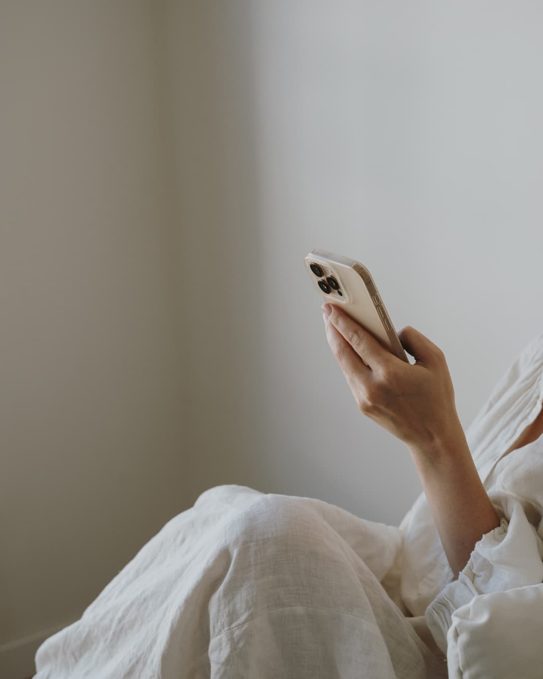 Clémence consulte son téléphone dans un univers lumineux et naturel