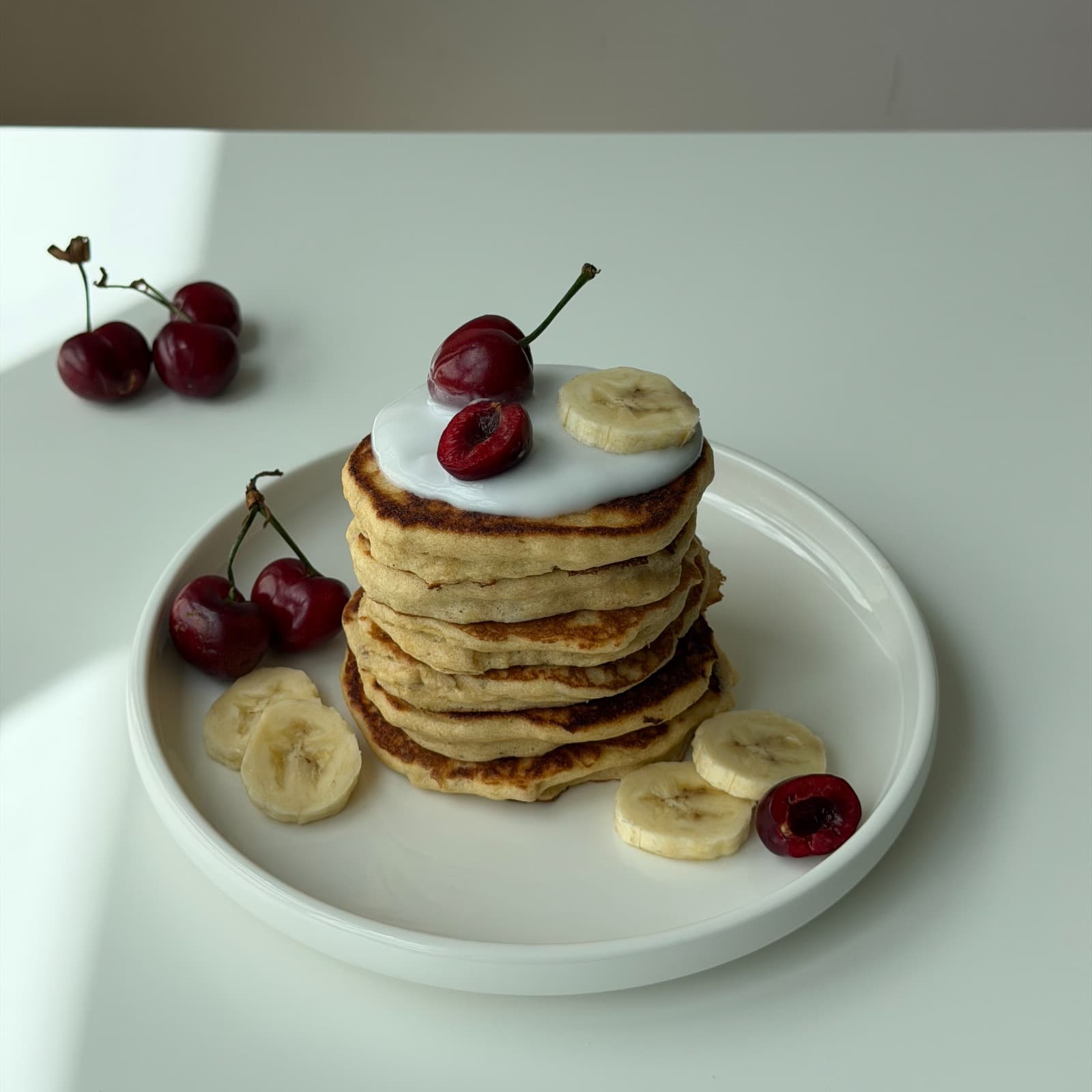 Pancakes aux cerises photographiés en lumière naturelle